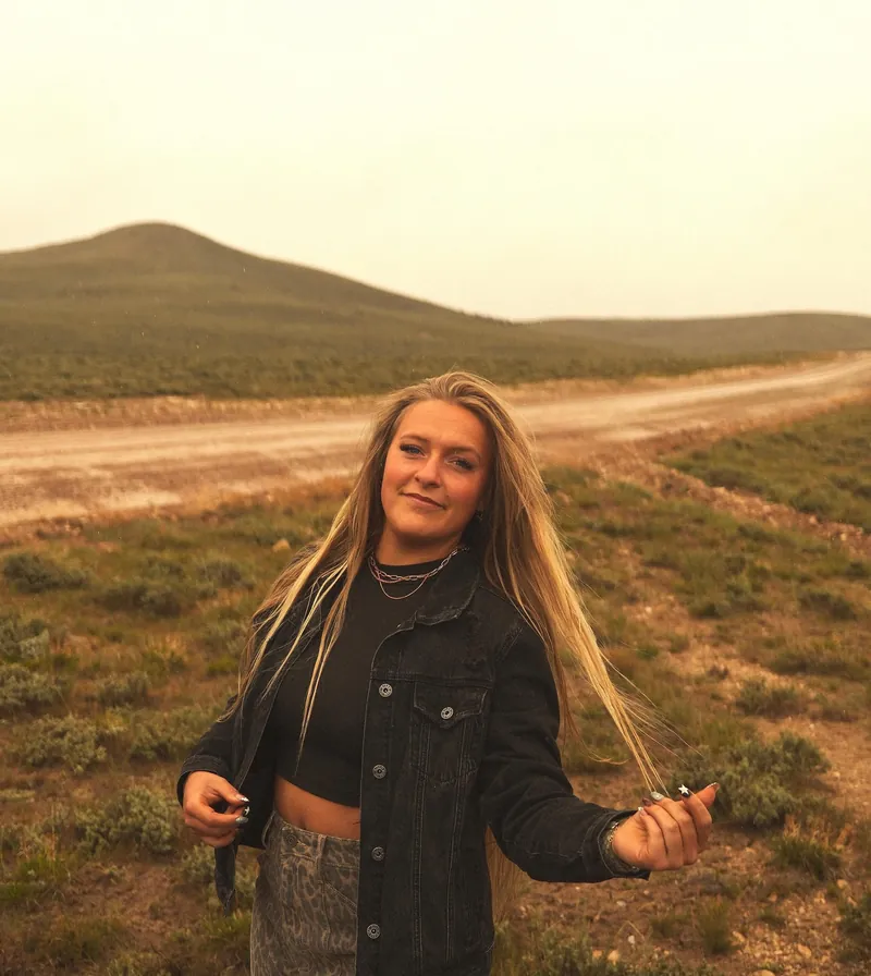 Kaylee Runolfson, owner of Kay's Detailing, outdoors in the Utah hills